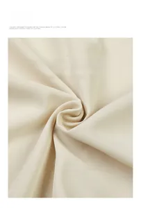 Vue détaillée de la texture du tissu sergé beige respirant et du drapé de la chemise