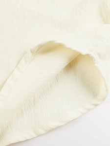 Close-up of textured cotton fabric hem and neat stitching on men's Henley shirt