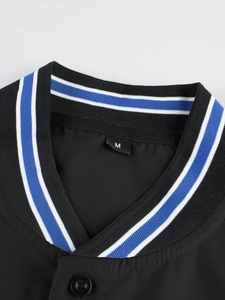 Detalle de cuello béisbol con ribete azul y blanco y etiqueta de talla M en tela negra