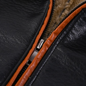 Dettaglio giacca in pelle nera con bordo a contrasto arancione e fodera in pile calda