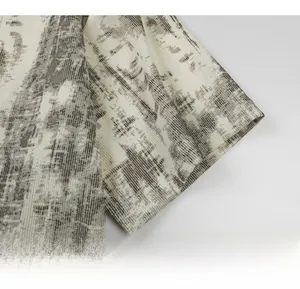 Gros plan sur le tissu gris tie-dye d'un t-shirt homme à col en V avec détails de couture