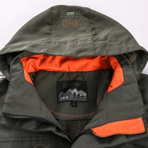 Close-up of olive green jacket neckline with contrast orange mesh lining and zipper