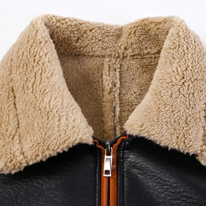 Dettaglio giacca in pelle nera con colletto in shearling e finiture della zip arancioni