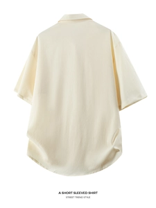 Detailed back view of beige short-sleeved shirt with textured fabric and dropped shoulders