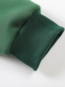 Detailed macro shot of dark green ribbed cuffs and smooth knit fabric on men's hoodie