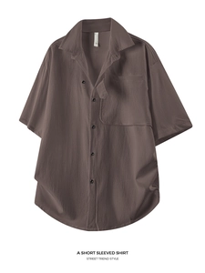 Close-up of texture on loose fit dark brown short sleeve shirt with chest pocket