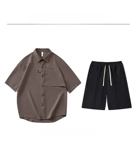 Mise à plat d'une chemise marron à manches courtes et d'un short noir avec poches
