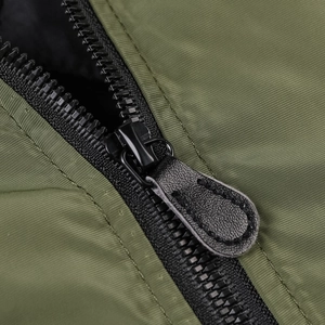 Close-up of olive green bomber jacket featuring a sturdy black zipper and textured fabric