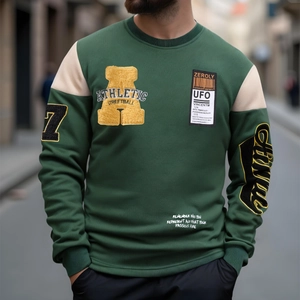 Close-up of vintage green hoodie featuring athletic embroidery and towel-stitched letters
