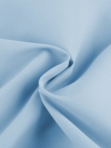 Vue macro du tissu bleu clair de haute qualité montrant la texture fine et le drapé