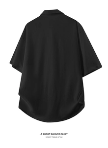 Detail of loose fit black short sleeved shirt with textured fabric and street trend style
