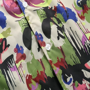 Detail of breathable ice silk fabric with graffiti print and white resin buttons