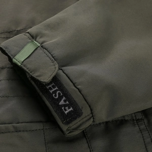 Detail view of military green jacket cuff with adjustable FASH velcro strap