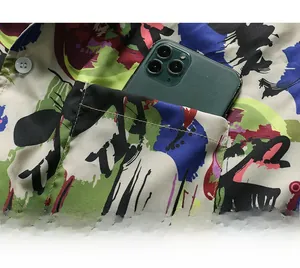 Detail shot of the chest pocket on a printed summer shirt holding a smartphone