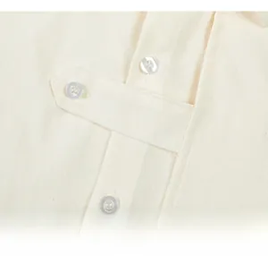 Close-up of beige textured fabric featuring decorative strap and ivory white buttons