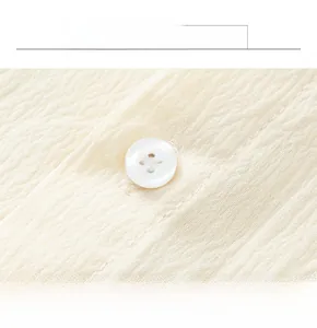 Vue macro d'un tissu gaufré texturé avec un bouton en résine blanche nacrée