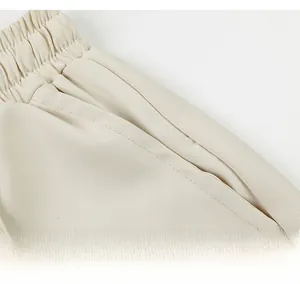 Détail de la taille élastique et poches latérales sur short beige en soie glacée