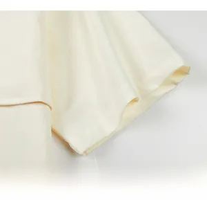 Macro detail of off-white shirt sleeve with textured fabric and fine stitching