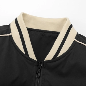 Macro shot of baseball collar featuring cream ribbed knit with black stripe and zipper