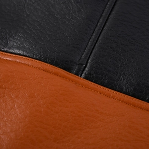 Dettaglio macro della trama in ecopelle con cuciture in colori a contrasto nero e arancione