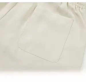 Détail de la taille élastique crème et de la poche arrière carrée sur un short d'été