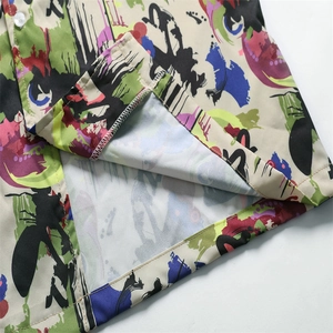 Detailed close-up showing the hem stitching and colorful abstract print on a summer shirt