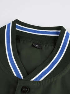 Detalle de cuello en V a rayas y botón en camisa de exterior color verde oscuro
