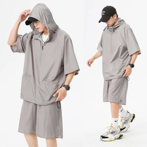 Detail eines grauen Kurzarm-Kapuzenpullovers und Shorts-Sets mit atmungsaktivem Mesh-Gewebe