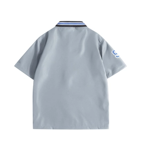 Detail of grey polo shirt with tricolor striped collar and number 9 patch on sleeve