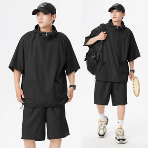 Detail eines schwarzen Techwear-Sportsets mit Kapuzenoberteil und passenden Shorts