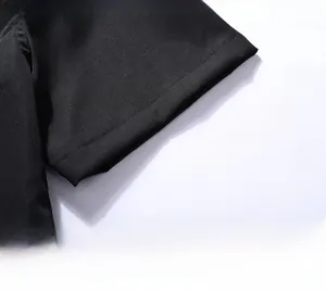 Detail view of double-stitched sleeve cuff on black polo shirt with breathable cotton fabric