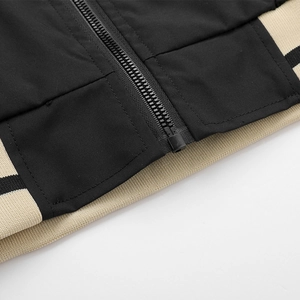 Detailed close-up of jacket hem with ribbed cuffs, striped design, and smooth black zipper