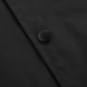 Detail of matte black snap button and precision double-stitched seams on the jacket fabric
