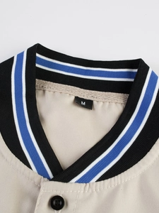 Detalle del cuello de béisbol con ribete a rayas y etiqueta de talla M en camisa beige