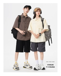 Detailed shot of couple's loose-fit summer cargo shirts with textured fabric and utility pockets