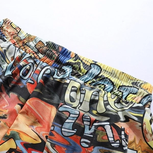 Detail view of colorful graffiti print beach shorts with elastic waistband and side pockets