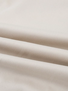 Primer plano de la textura de tela beige con tejido fino y suaves pliegues naturales
