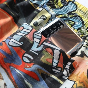 Detail of elastic drawstring waistband and deep side pocket on graffiti print beach shorts