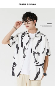 Detail display of men's white Hawaiian shirt with black abstract ink prints and trendy style