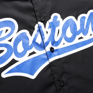 Close-up of black polo shirt featuring textured fabric and blue Boston letter print