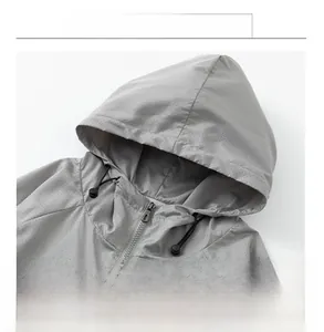 Detail of grey outdoor hooded jacket featuring breathable micro-perforated fabric and drawstring