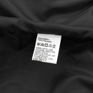Macro shot of 100% polyester wash care label and fabric detail for men's baseball jacket