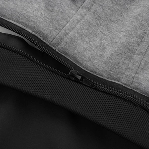Detail of grey marl fabric, smooth black zipper, and ribbed cuff on men's jacket