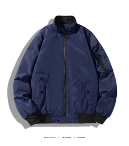Close-up of navy blue bomber jacket showing MA-1 sleeve pocket and windproof fabric