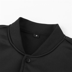 Detail of ribbed collar and M size tag on black knitted varsity jacket with snap button