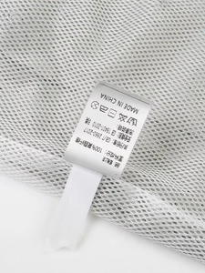Weißes, atmungsaktives Mesh-Sportoberteil mit Stoffetikett aus 100 % Polyester-Detail