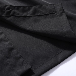 Close-up of the black polo shirt hem with double-needle stitching and smooth satin finish