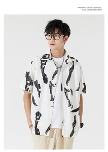Close-up of men's loose short-sleeve shirt with black abstract ink-stroke patterns