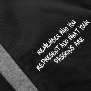 Detail of embroidered white text on high-density black and grey knit jacket fabric