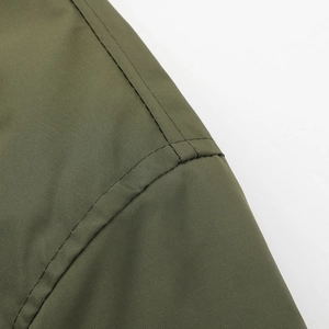 Detail macro shot of army green breathable fabric with reinforced double stitching line